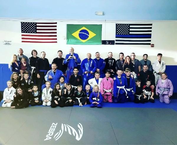 Adults and children of the academy together on the mats