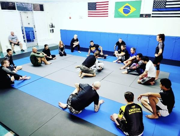 A small class gathered around the mat for instruction